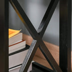Black X-frame support detail on end table with lower shelf visible