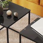 Close-up of black tempered glass top and metal frame on a nesting coffee table