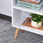 White and grey bookcase with grey drawer front, open side shelves, and light wood legs.