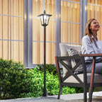 Black solar lantern-style pathway light on a tall post with clear glass panels.