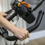 Close-up of a stationary exercise bike handlebar grip with control buttons