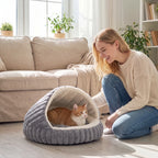Grey plush cat cave bed with arched opening; orange kitten inside