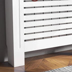 Close-up of white radiator cover grille with horizontal slat panels and side support.