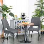 Round coffee table with wood-look top and black pedestal base in dining setting