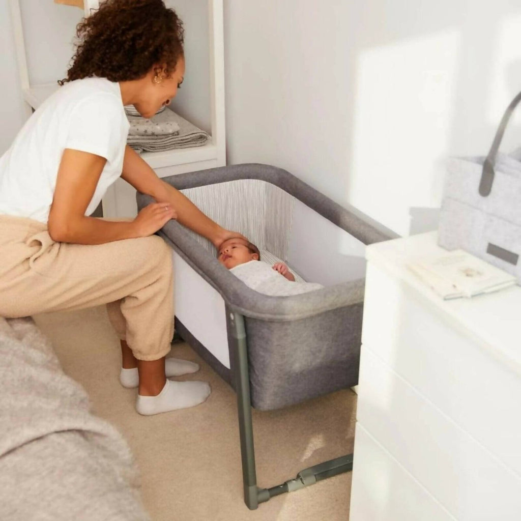 Space Grey mini crib used in a room setting with person and baby visible.