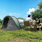 Dark green and gray 4-person pop-up camping tent set up in a yard with doors open