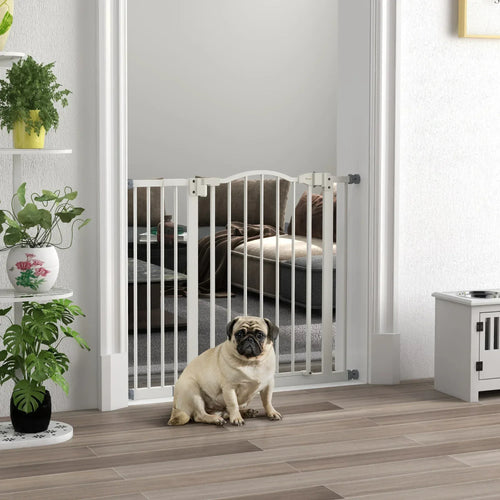 White pet gate barrier with auto-close doorway, dog sitting behind the bars