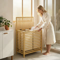 Bamboo laundry hamper with lid and slatted front, viewed from front-left angle