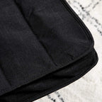 Black linen-textured upholstery fabric on a padded lounge chair seat