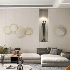 Gold-tone metal wall mirror set with five interlocking circular frames on a living room wall