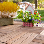 Brown interlocking wood deck tiles laid on patio floor with floral planter decor