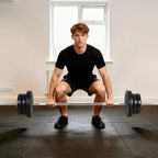 Black barbell with weight plates during a home squat exercise