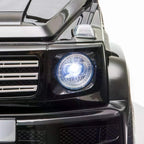 Close-up of black kids electric ride-on car front headlight with bright LED glow