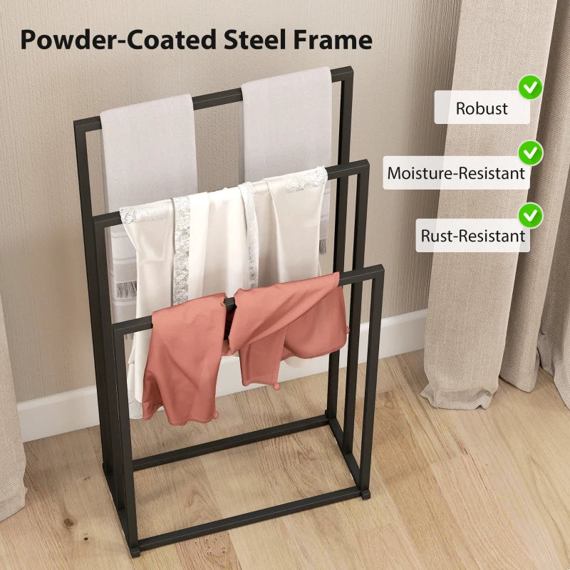 Black steel towel rack with three bars, holding white towels and an orange cloth.