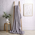 Silver chunky fleece throw blanket draped from two wooden hooks