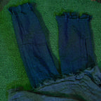 Grey tattered zombie prop legs and cloth body on green grass
