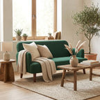 Dark green loveseat sofa with wooden legs and decorative cushions on the seat