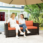 Orange outdoor garden sofa with dark woven rattan frame and cushioned bench seat