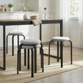 Set of 4 grey backless stools with round cushioned seats, stacked to save space