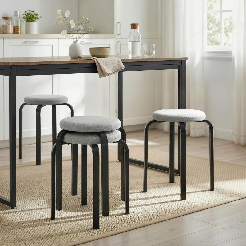 Set of 4 grey backless stools with round cushioned seats, stacked to save space