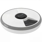 Grey and white automatic cat feeder with circular lid and black control button