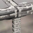 Close-up of grey woven rattan chair frame corner with white-and-gray weave