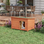 Outdoor wooden dog house with arched doorway, green roof panel; dog sitting inside