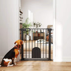 Black pet safety gate with cat flap, vertical bars, and dogs near the doorway
