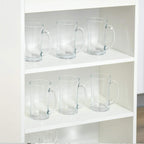 White shelf unit with clear glass mugs on multiple tiers
