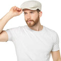 Stone beige linen cap with curved brim and textured fabric, worn by a model