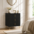 Black 3-drawer dresser with fluted fronts and gold bar handles, standing on gold legs.