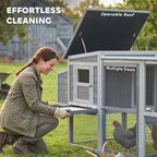 Grey wooden chicken coop with openable asphalt roof and slide-out tray