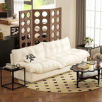Black nesting tables with tempered glass tops and metal frames near a white sofa bed