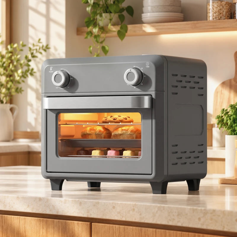 Grey countertop air fryer oven with front window showing cooking food, two knobs on top