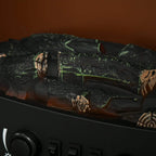 Close-up of electric fireplace log bed with orange LED flame glow behind glass