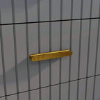Gold-tone bar handle on a dark grey dresser drawer with embossed vertical line design