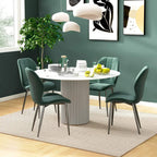 Emerald green upholstered dining chairs with quilted backs around a white round table