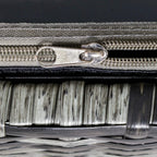 Close-up of dark seat cushion zipper and woven mixed grey rattan edge trim