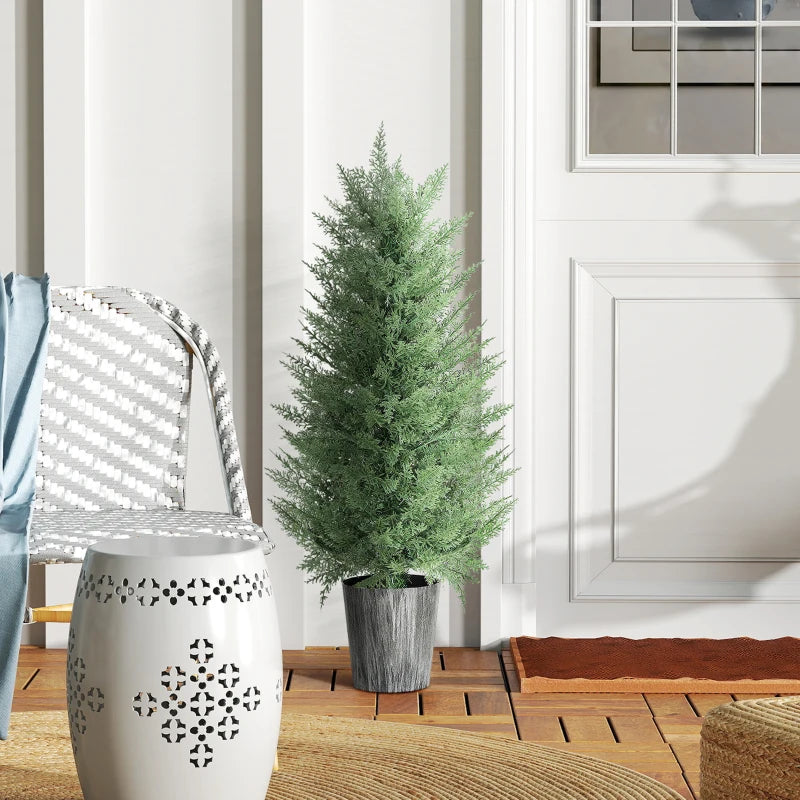 Artificial cypress tree with green foliage and gray textured pot by front door
