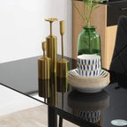 Black glass dining table with decorative candle holders and chair back