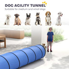 Blue dog agility tunnel with circular openings and black ring panels, on a yard lawn