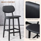 Black bar stool close-up: smooth faux-leather seat with thick padding and curved backrest