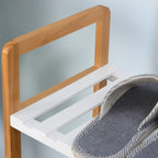 Close-up of four-tier shoe rack: natural wood side frame and white slatted shelf