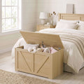 Wooden storage box beside a bed with open lid and stuffed toys inside