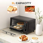 Black mini oven with glass door open, wire rack inside and baking tray pulled out.
