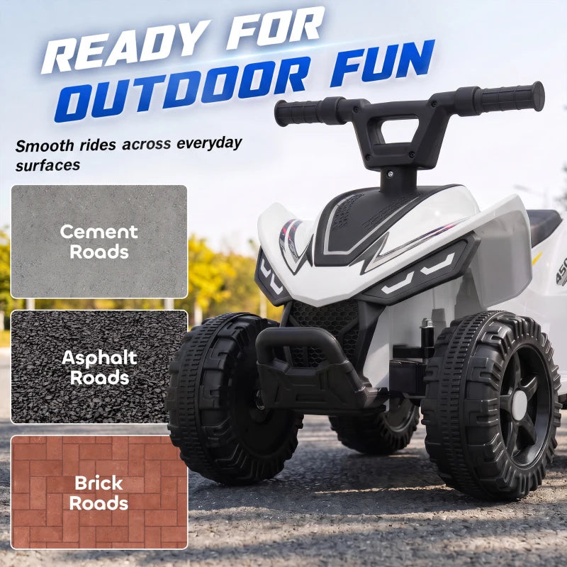 White kids quad bike with black tires on paved outdoor driveway