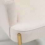 Cream upholstered armrest with gold metal leg detail close-up