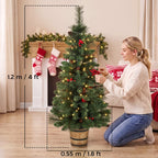 4 ft prelit Christmas tree in a pot with green needles, pinecones and berries, warm LED glow