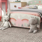 Kids pink bed frame with rainbow and forest print and plush bunny toys