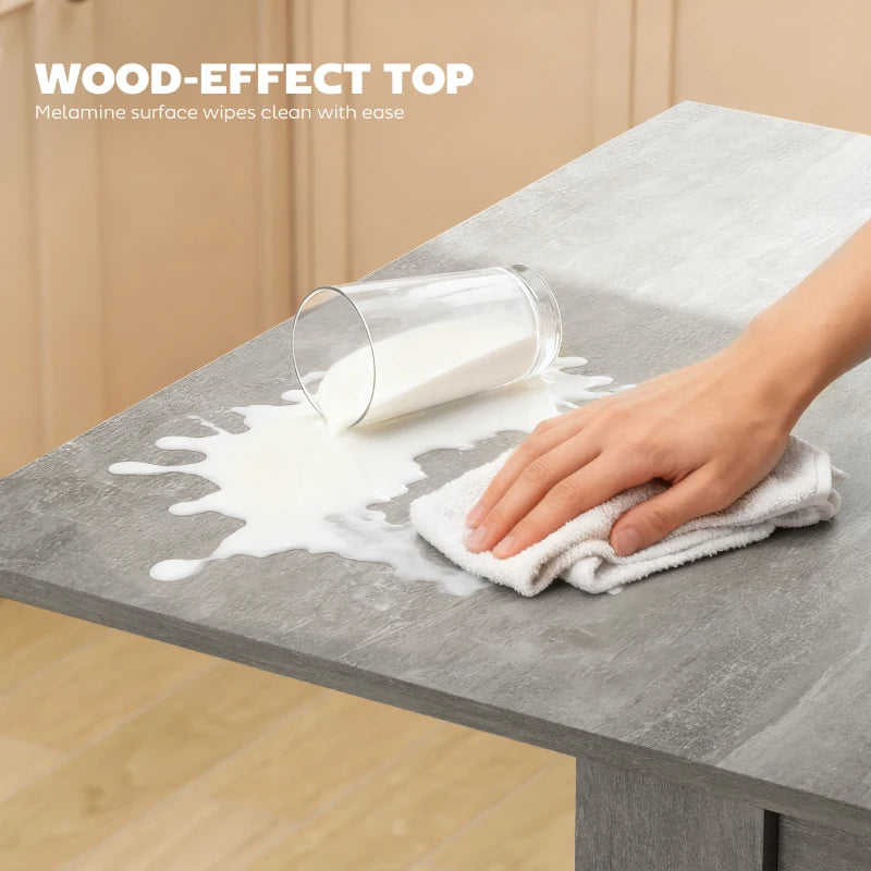 Grey wood-effect tabletop being wiped clean with a cloth.